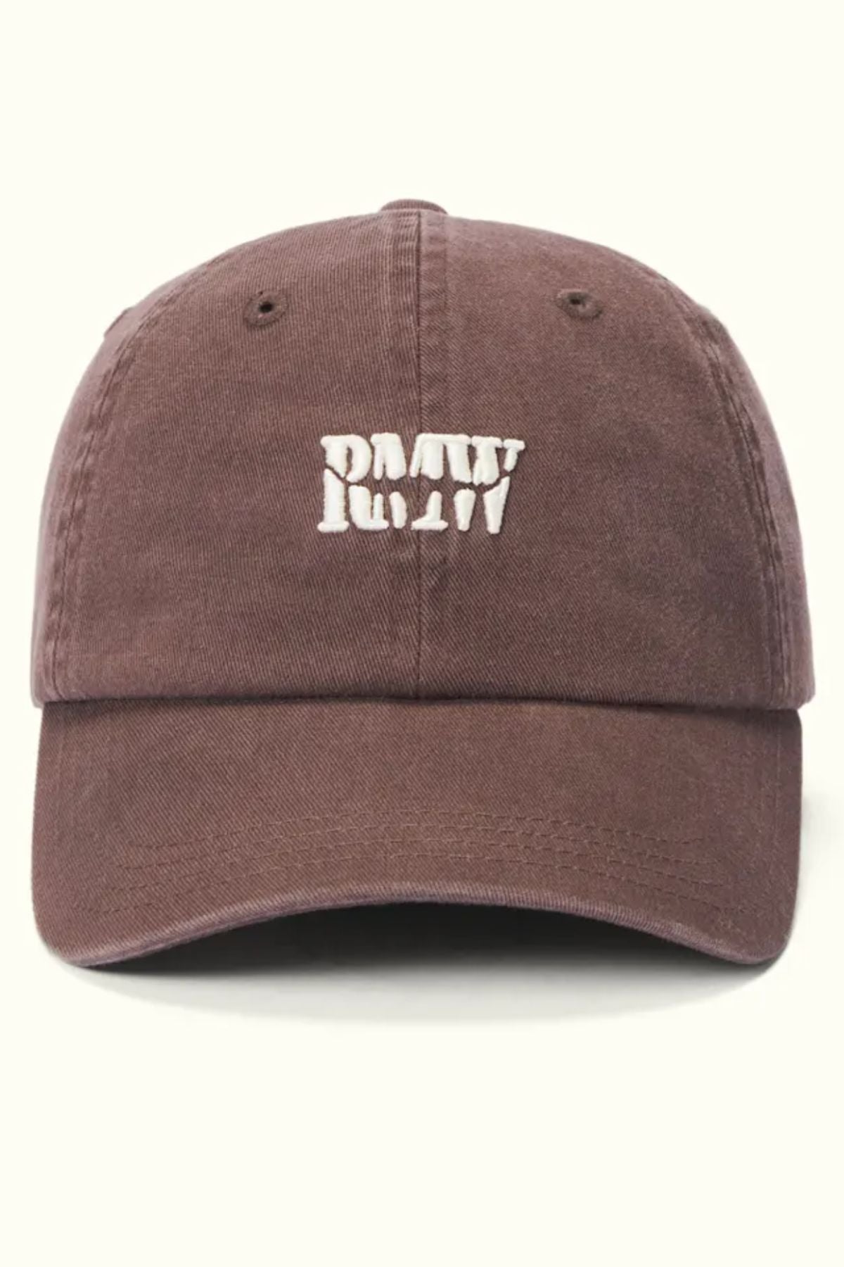 The RM Williams Branded Twill Cap is a brown organic cotton cap with a white embroidered “PMTW” heritage logo on the front, an adjustable strap, and is shown against a light background.