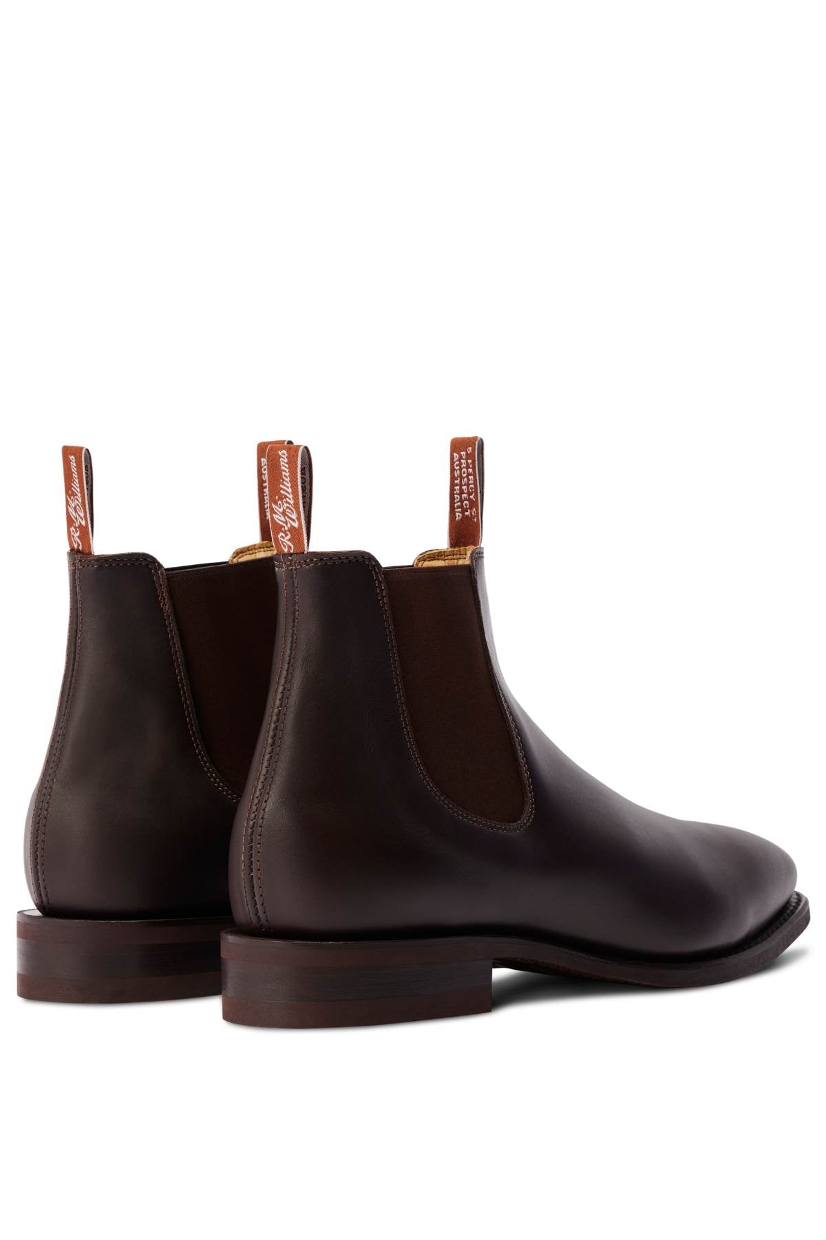 The RM Williams Comfort Craftsman Boot, a handcrafted leather Chelsea boot with elastic sides, pull tabs, and stacked wooden heels, is shown diagonally with the heels facing forward.