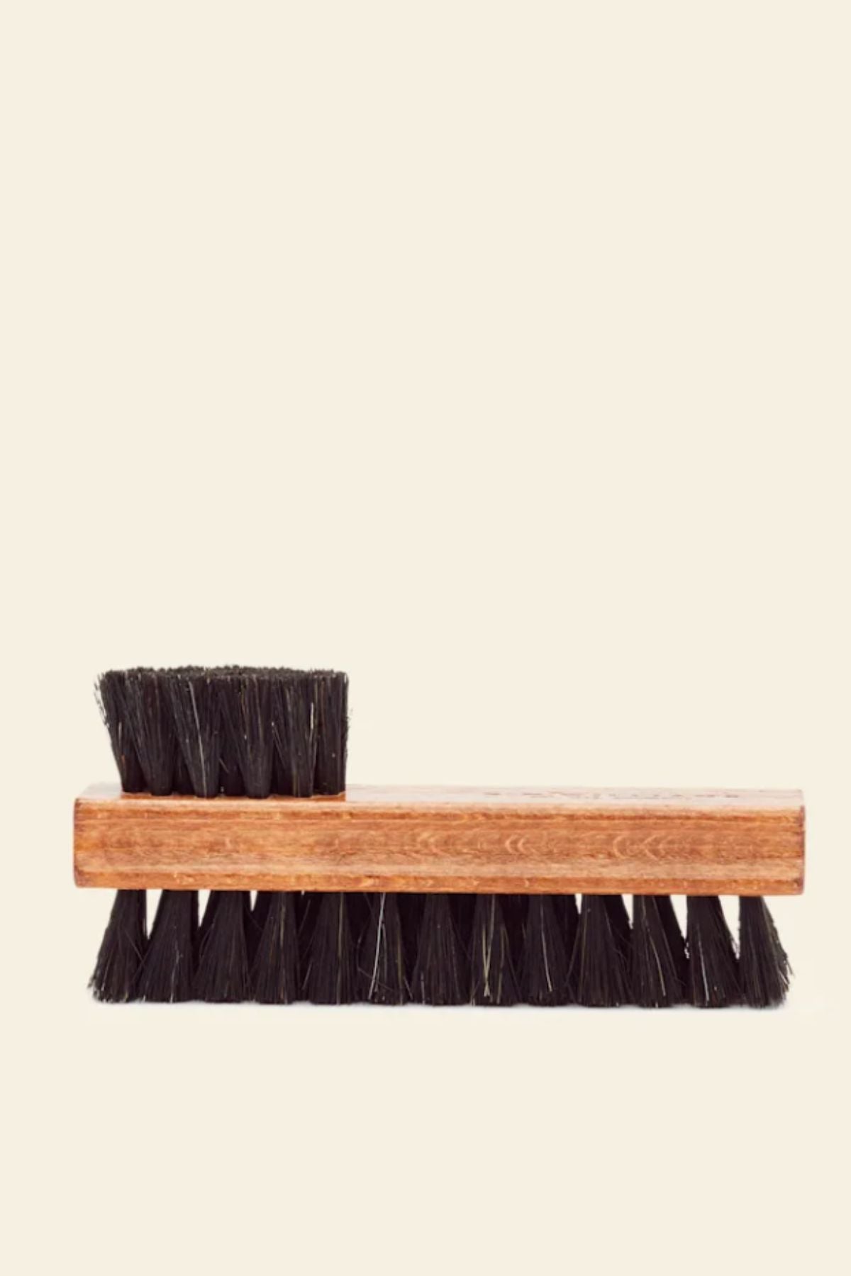 The RM Williams Double Sided Brush, made of wood with dense black bristles for leather boots, features a smaller brush on one end and is shown against a plain light background.
