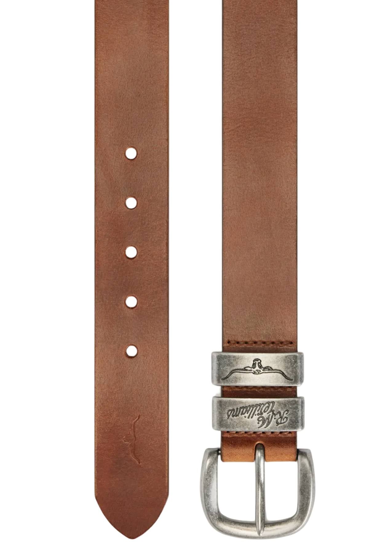 The RM Williams Drover Belt is crafted from premium brown leather with a smooth finish and pointed tip, featuring an antique silver engraved buckle and five adjustment holes.