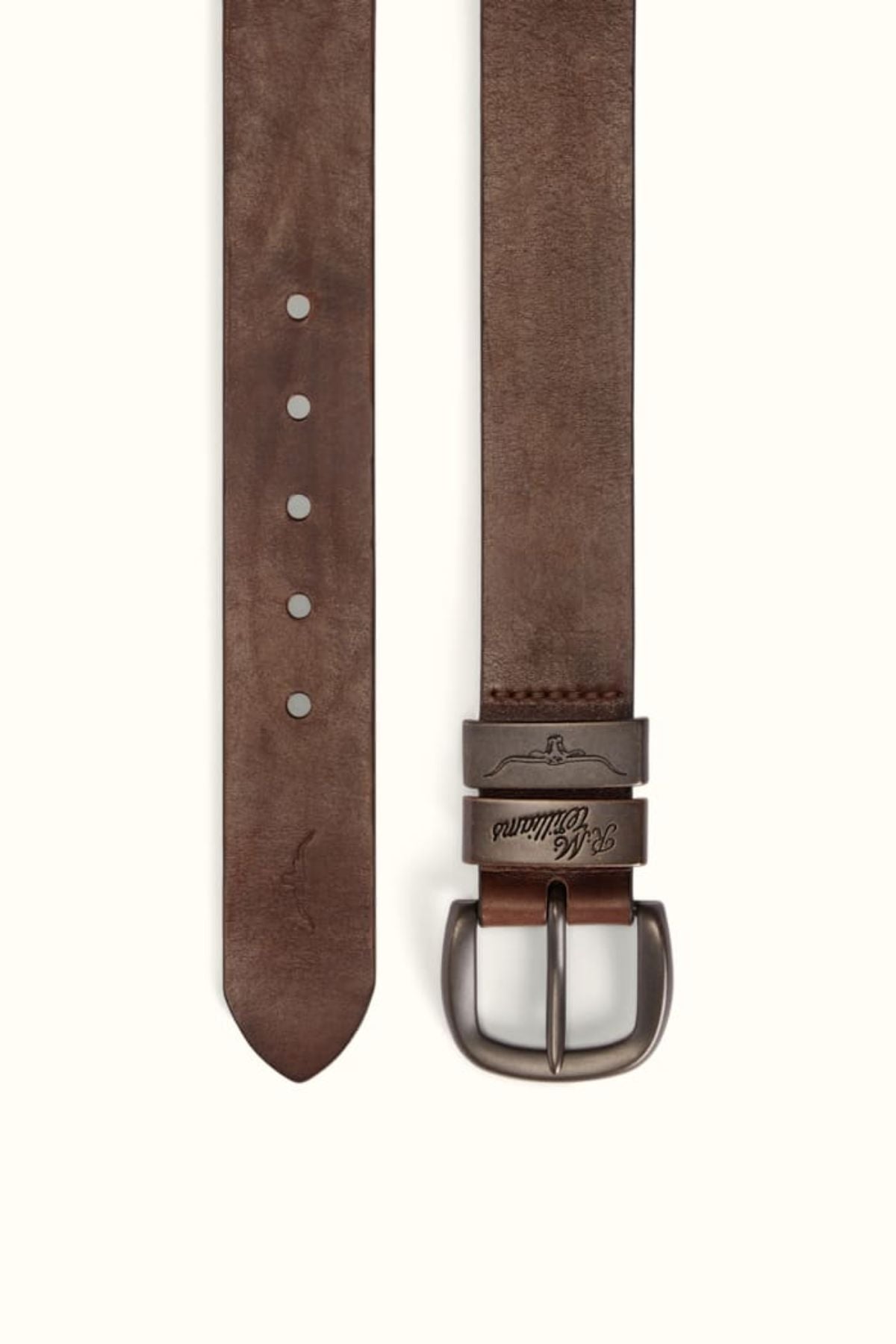 The RM Williams Drover Belt is a brown leather belt with double keepers, a silver engraved-branded buckle, and five holes, shown vertically with both the buckle and pointed tip visible.