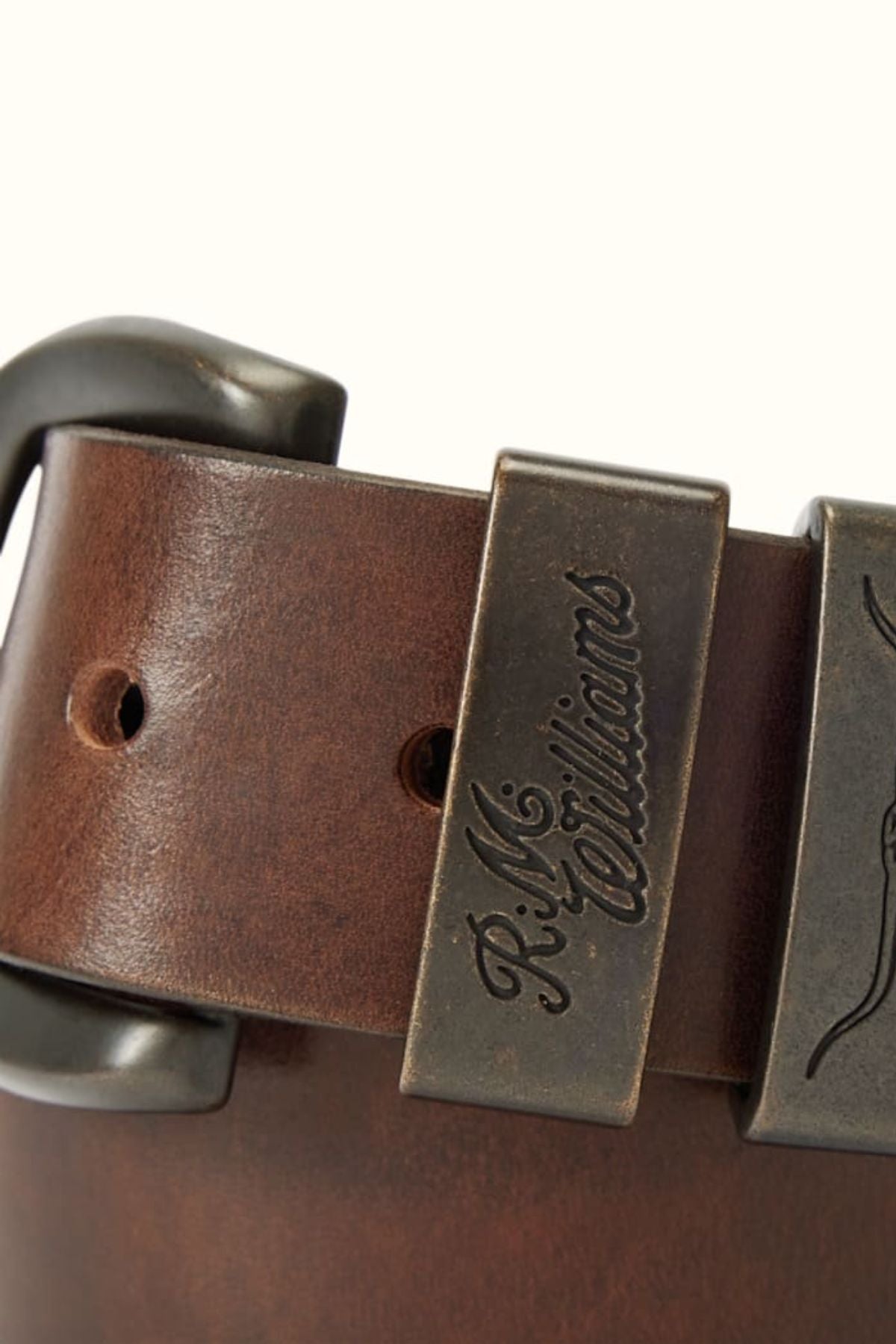 Close-up of the RM Williams Drover Belt in brown leather, featuring a metal buckle, double keepers, and a metal loop engraved with "R.M. Williams.