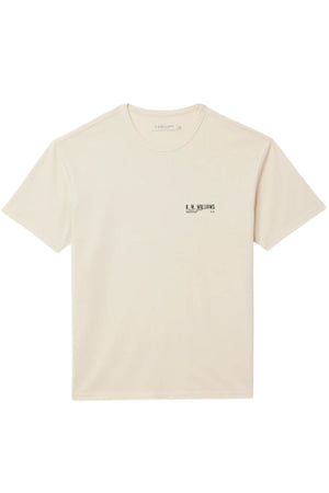 The RM Williams Flinders T-Shirt is a cream-colored, organic cotton jersey tee with short sleeves, a relaxed fit, and a small black βR.M. Williamsβ logo on the left chest. It is shown laid flat against a white background.