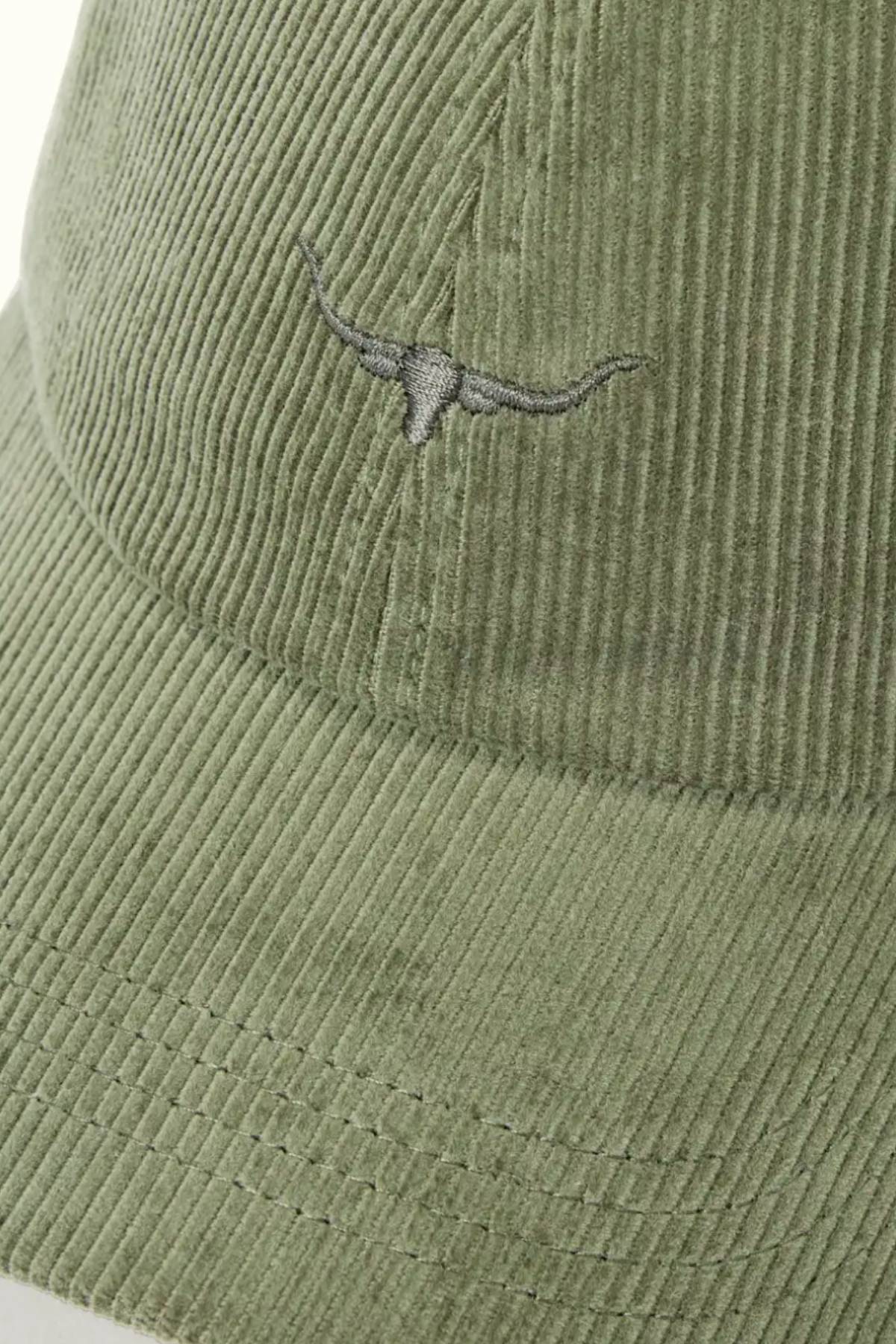 A close-up of the RM Williams Mini Longhorn Cord Cap in light green organic cotton corduroy, featuring an embroidered mini Longhorn logo on the front and an adjustable strap at the back.
