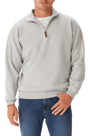 A man wears the RM Williams Mulyungarie Fleece pullover over a white shirt and blue jeans, standing with one hand in his pocket against a white background.