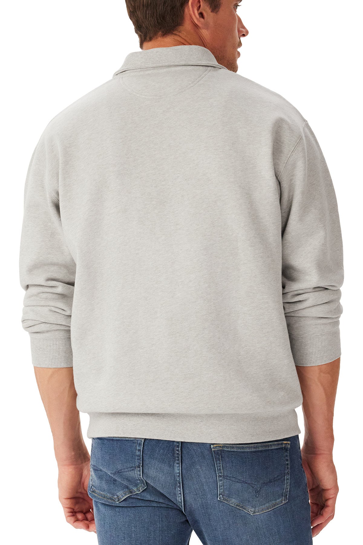 A man is seen from behind wearing the RM Williams Mulyungarie Fleece, a light gray organic cotton long-sleeve sweatshirt, paired with blue jeans. He stands with his arms relaxed at his sides.