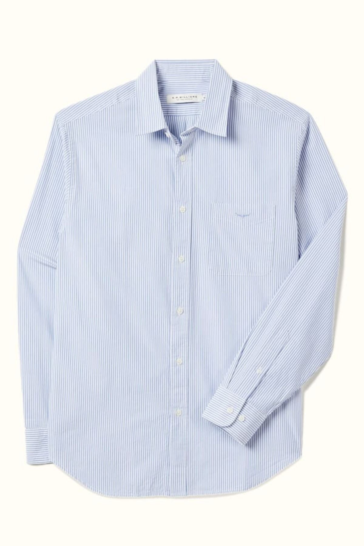 The RM Williams Regular Poplin Stripe Shirt features light blue and white stripes, organic cotton, a regular fit, long sleeves, front pocket, and subtle Longhorn embroidery, shown laid flat on a light background.