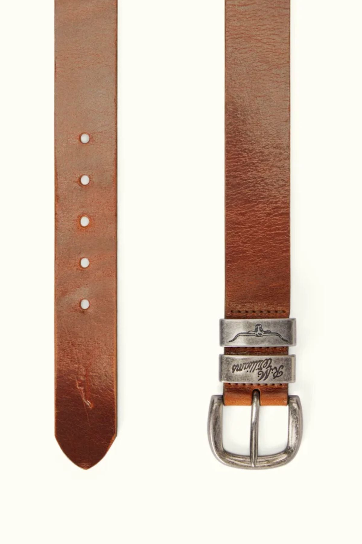 The RM Williams Drover Belt, made in Australia, features brown pull-up leather, a silver metal buckle, and multiple adjustment holes, shown against a light background.