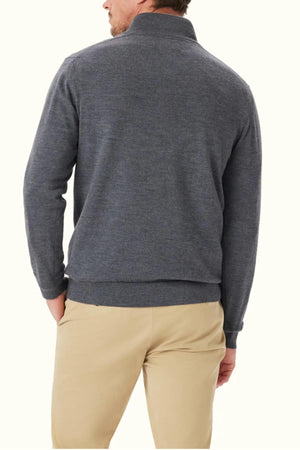 A man stands with his back to the camera, wearing the RM Williams Ernest 1/4 Zip Merino Knit sweater in gray and beige pants against an off-white background.