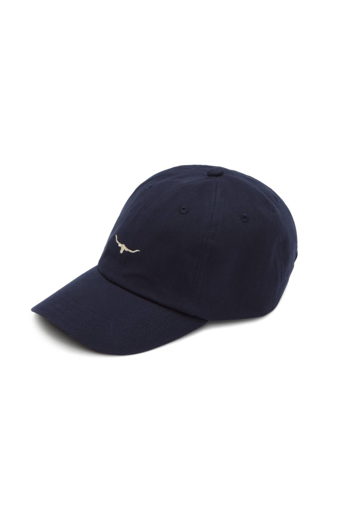 The RM Williams Mini Longhorn Twill Cap is a navy blue organic cotton cap with a small white embroidered mini Longhorn logo on the front and an adjustable strap, shown on a plain white background.
