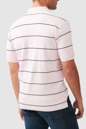 A man, seen from the back against a plain light gray background, wears a light pink Rodd & Gunn Glen Eden Polo with blue jeans.