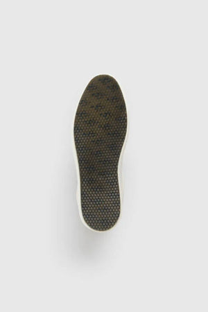 The Rodd & Gunn Transit Sneaker is shown from the bottom, revealing a dark, textured hexagonal sole against a light background. Crafted from high-quality leather, it combines durability with style.