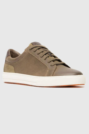 A single Rodd & Gunn Transit Sneaker in olive green, featuring brown laces, textile and leather panels, a low-top design, and a white translucent outsole, displayed on a light gray background.
