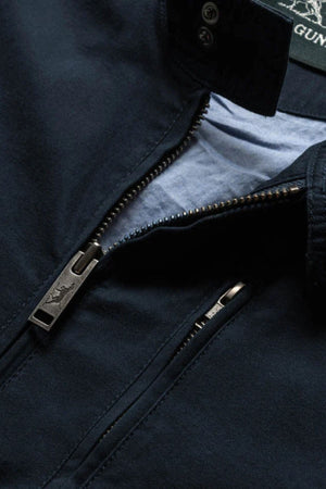 Close-up of the Rodd & Gunn Armitage Jacket for men in navy blue, featuring a partially unzipped zipper that reveals a light blue Australian Cotton lining and a branded zipper pull.