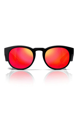 A pair of SafeStyle Cruisers sunglasses with a matte black frame and mirror red polarised lenses rests against a white background, boasting a fiery gradient from yellow to red while providing excellent UV protection.