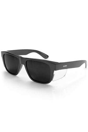 SafeStyle Fusions XL Black Frame Tinted Lens safety glasses feature thick black frames, UV-protective tinted lenses, clear side shields, and the SafeStyle logo in white on the temples. Displayed on a white background.