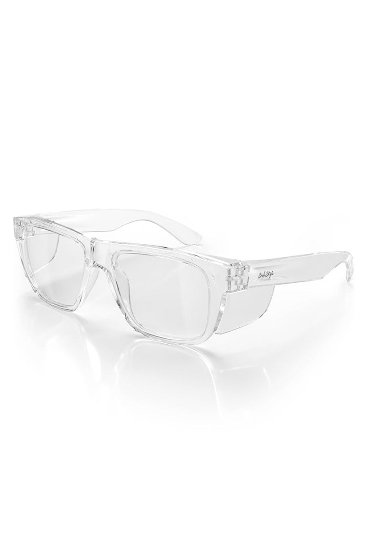 SafeStyle Fusions XL eyeglasses, with transparent shatterproof frames and clear lenses, sit on a white surface. They feature subtle sheen and UV protection, offering a modern and simple design that blends safety with style.