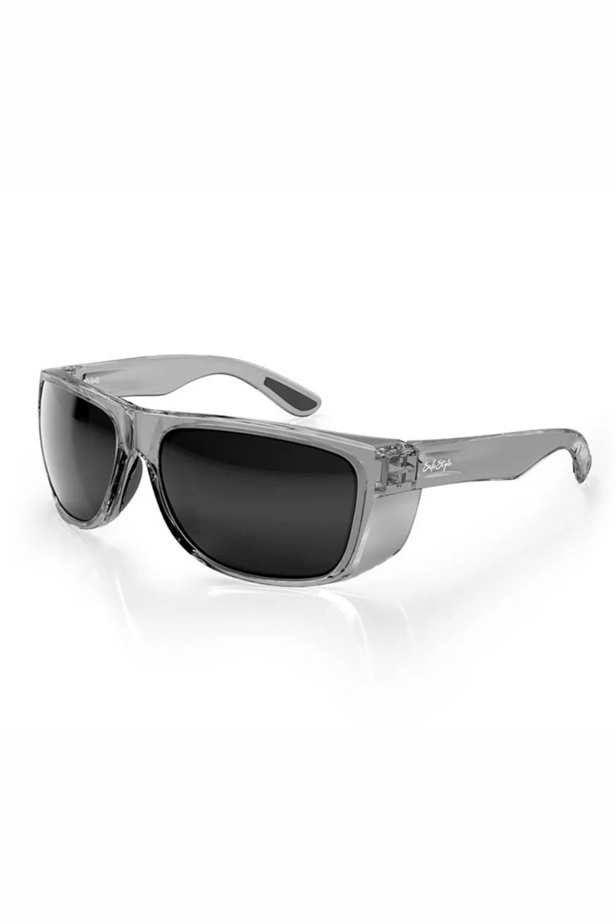 The SafeStyle Rapids Graphite Frame Polarised Lens sunglasses feature a transparent gray frame, large dark polarised lenses, thick arms, and a slightly wraparound shatterproof design for bold style and UV protection. Shown on a white background.