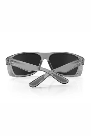 The SafeStyle Rapids Graphite Frame Polarised Lens sunglasses are shown from the back with crossed arms and visible side logo, featuring shatterproof dark lenses for stylish UV protection against a white background.