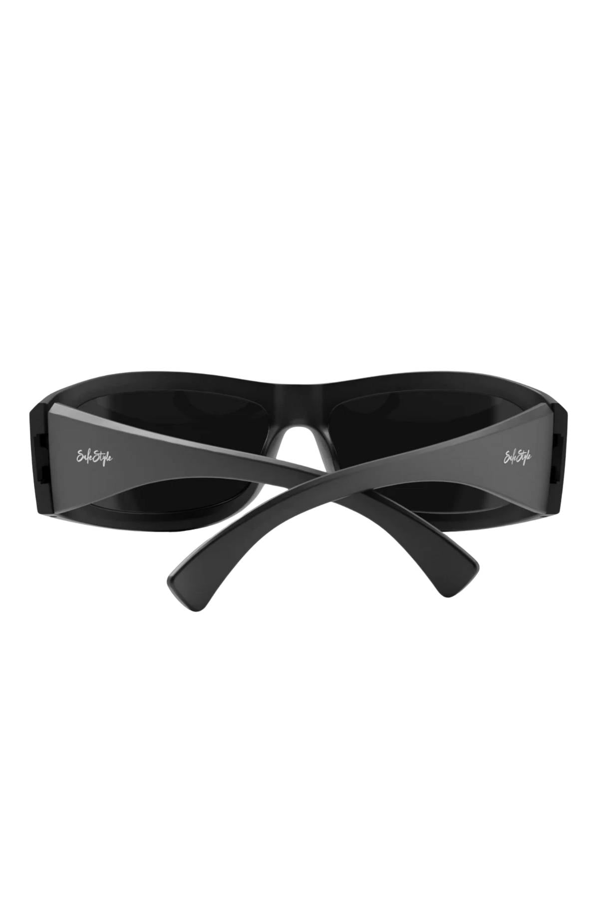 A pair of SafeStyle Sonics Matte Black Frame Polarised Lens sunglasses shown from the back, with crossed arms. These stylish frames feature "Sub-Zero" in white on both arms and offer UV protection for your eyes.