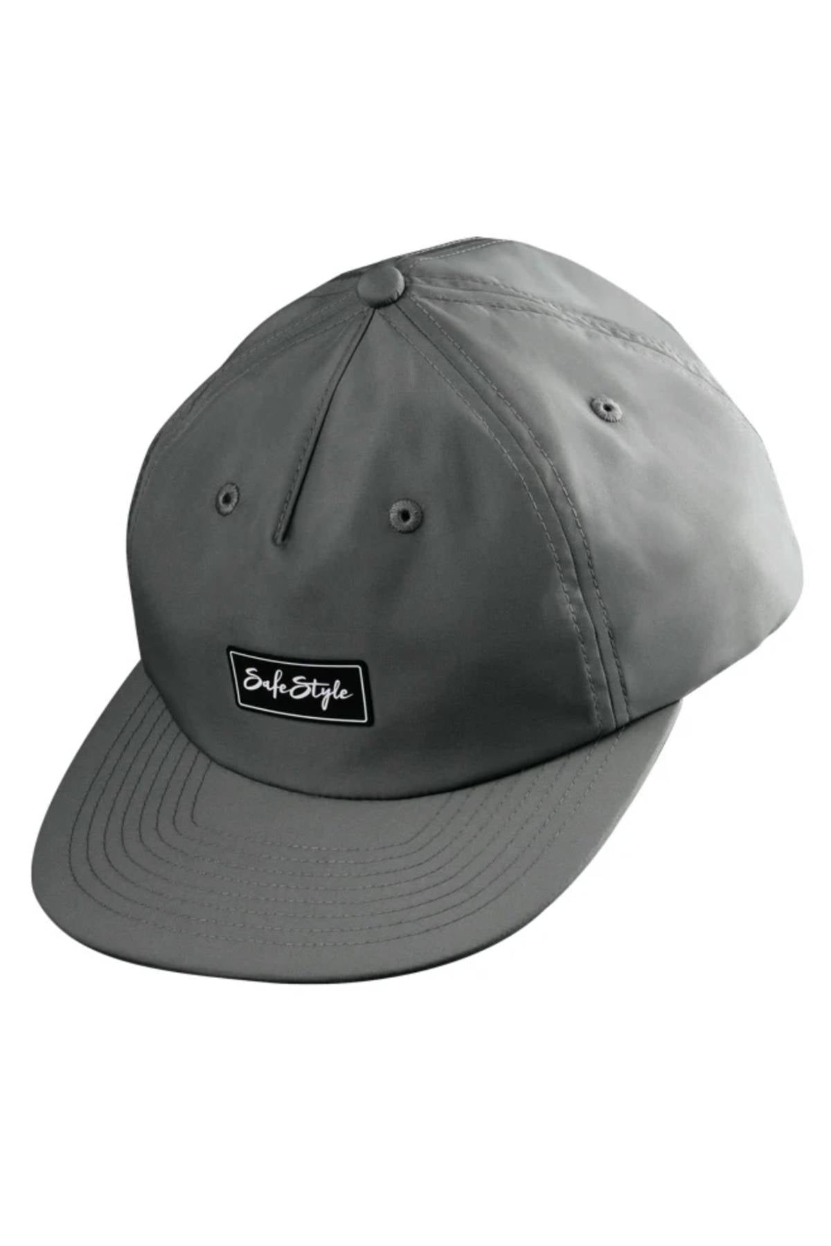 The Safestyle Worksite to Weekend Essentials Cap is a gray baseball cap made from 100% recycled polyester, featuring a curved brim, black "SafeStyle" patch, stitched panels, metal eyelets for ventilation, and quick dry technology for comfort.