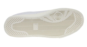 The image displays the sole of a white Superga 2843 Club S Comfort Leather Sneaker, featuring a vulcanised gum sole with a geometric pattern, herringbone grooves for traction, and a circular design at the heel.