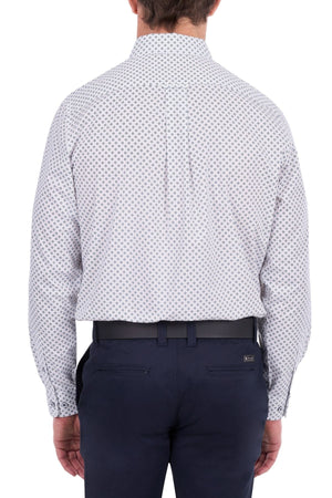 A man is shown from the back, wearing the Thomas Cook Albie Shirt—a long-sleeve, light-colored patterned workwear shirt—tucked into dark blue dress pants with a black belt.