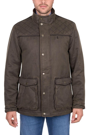 A man wears the Thomas Cook Marcus Jacket, a brown quilted faux oilskin style with button closures and two large front pockets, paired with blue jeans. The image is cropped below his nose, obscuring his eyes.