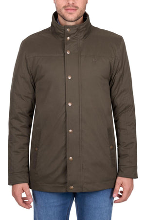 A man in a dark olive-green Thomas Cook Matt Jacket with a high collar and blue jeans stands against a white background. The midweight puffer has two front pockets, metal snap buttons, and provides weather protection.