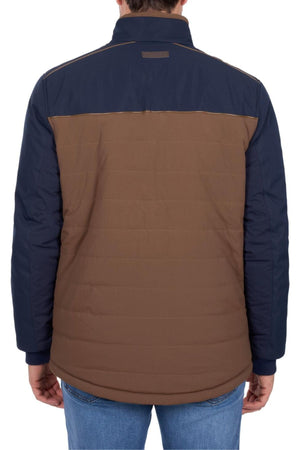 A person wearing the Thomas Cook Toby Reversible Jacket, featuring a color-blocked design with a dark blue upper and brown lower section, seen from the back. They are also wearing blue jeans.