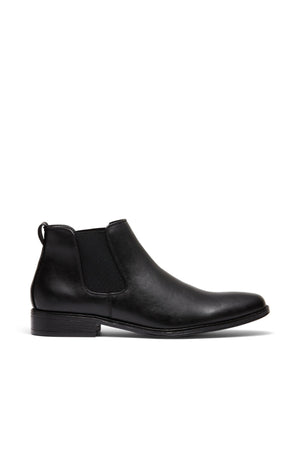 The UNcut Canterbury Boot is a durable black leather Chelsea boot with elastic side gussets, a low heel, and a back pull tab, shown in profile on a white background.