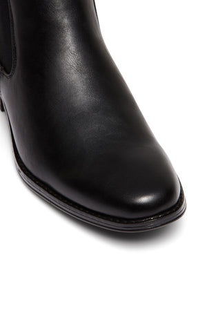 Close-up of the UNcut Canterbury Boot's toe and upper, showcasing smooth black leather, detailed stitching along the sole, and signature side gussets against a white background.