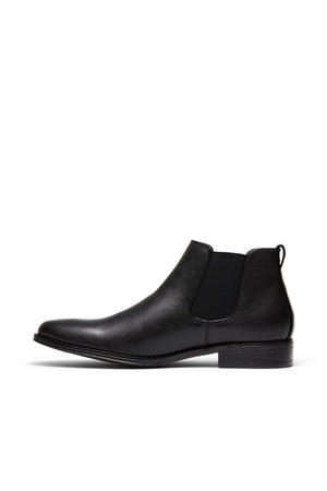 The UNcut Canterbury Boot is a durable black leather Chelsea boot with elastic side gussets, a rounded toe, low heel, and back pull tab, displayed in side profile against a white background.