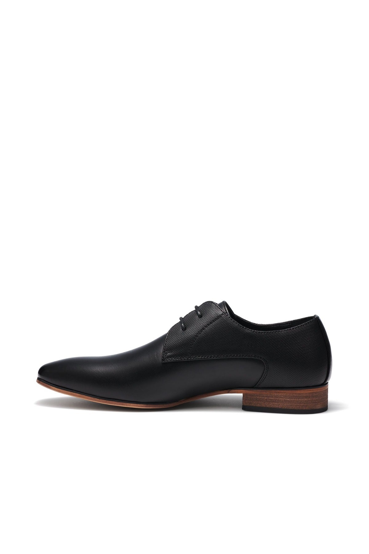 The UNcut Chartwell Shoe is a sleek black leather dress shoe with a pointed toe, brown wooden heel, and black laces. Its smooth finish and embossed upper panel make it perfect for formal events, elegantly showcased from a side profile against a plain white background.
