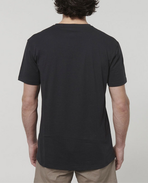 A person with short, wavy hair is seen from the back, wearing a Hard Yakka Core Tee crafted from 100% Australian cotton along with beige shorts against a plain, light grey background.