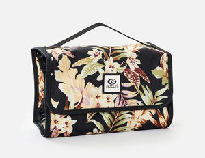 The Rip Curl Rolled Beauty Sunday Swell toiletry bag showcases a tropical floral design on a sleek black background. With waterproof pockets, a small top handle, and the brand logo on the front flap, it stylishly stores your essentials.