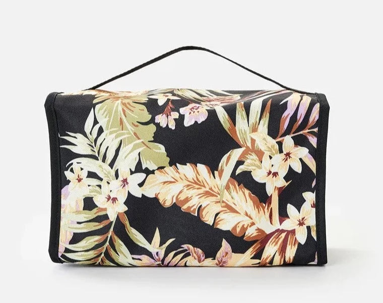 The Rip Curl Rolled Beauty Sunday Swell Toiletry Bag features a striking floral pattern with large orange, green, and white leaves and flowers. It includes a top handle and waterproof pockets, combining style and practicality effortlessly.