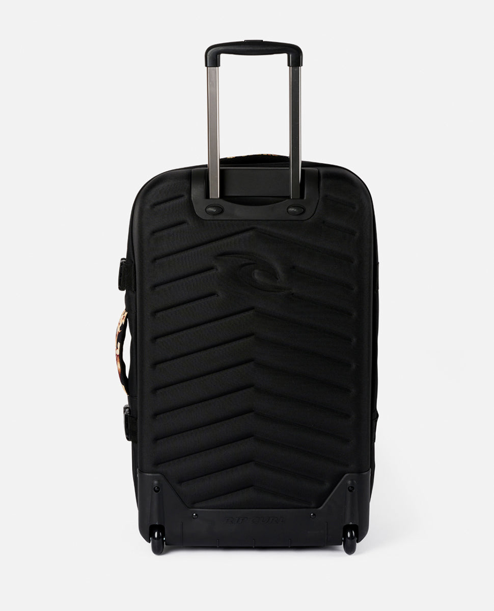 The Rip Curl F-Light Global 110L Sunday Travel Bag is black with a textured surface and telescopic handle, featuring lockable zips, two wheels, and an embossed logo on the front.