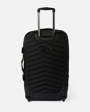 The Rip Curl F-Light Global 110L Sunday Travel Bag is black with a textured surface and telescopic handle, featuring lockable zips, two wheels, and an embossed logo on the front.