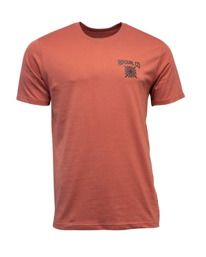 The Rip Curl Cosmic Burst Tee is a faded red, short-sleeve crew-neck T-shirt made from 100% cotton, featuring a small "Rip Curl Co" logo and graphic on the left chest. Displayed on a plain white background.