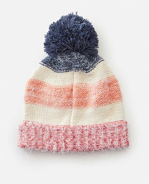 The Rip Curl Surf Tree House Pom Pom Beanie has a knitted design with a playful pom-pom, featuring blue, cream, and pink horizontal stripes and a fuzzy pink textured bottom edge.