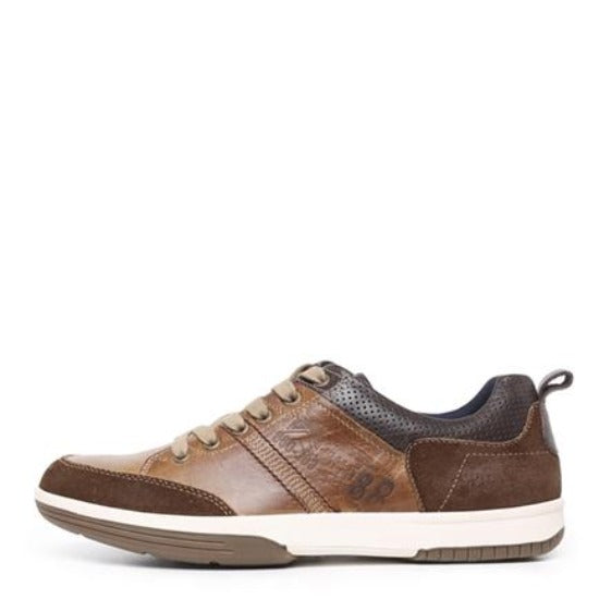 Introducing the Colorado Victor Casual Shoe: a lace-up sneaker made of premium brown leather, enhanced with beige accents and matching brown laces. It features a perforated black collar for added breathability, a sturdy white and brown rubber sole, and a distinctive side stripe design. A small tab at the heel complements this stylish shoe that effortlessly blends casual and sporty elements.