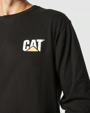 A person wears a black, 100% cotton CAT Trademark Banner Long Sleeve Tee with the iconic white and yellow logo on the chest, highlighted against a plain background.