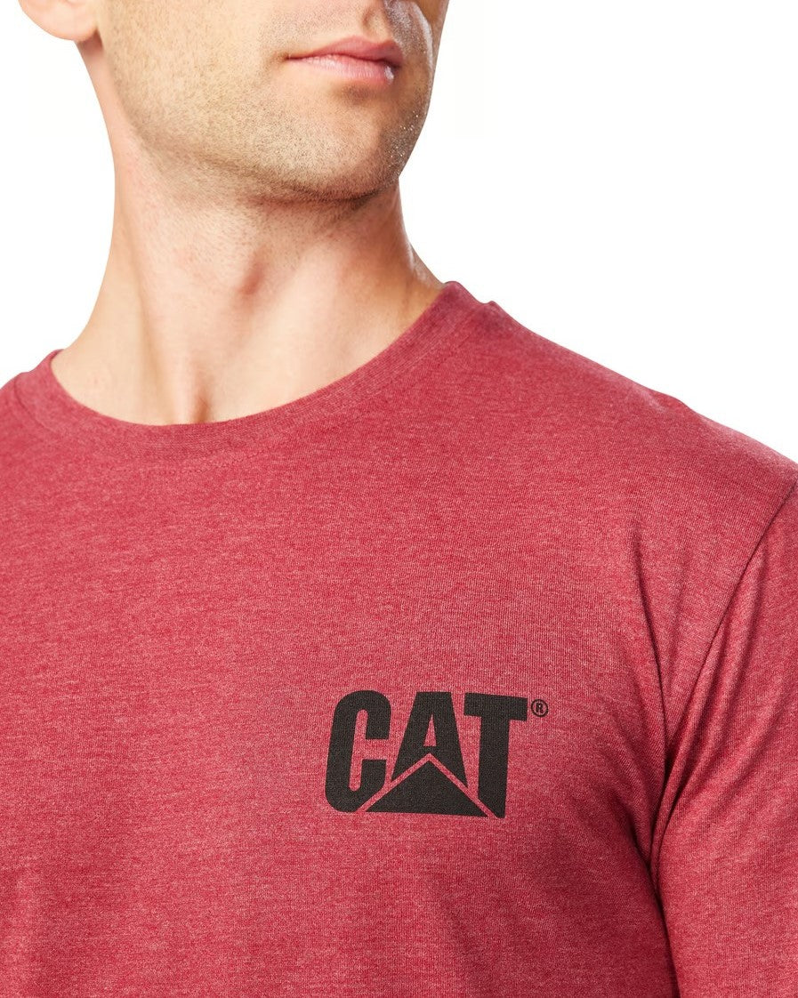 Someone is wearing a comfortable red CAT Trademark Banner Long Sleeve Tee, featuring a black "CAT" logo on the chest against a plain white background.