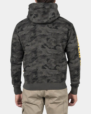 A person is shown from the back wearing a CAT Trademark Banner Hooded Sweat in gray camouflage with fleece lining, hood up, and khaki cargo pants. The background is plain white, and the sleeve features yellow text.