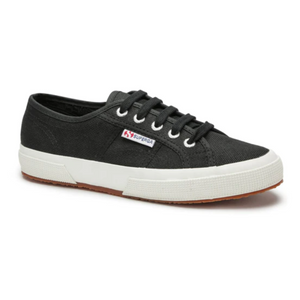The Superga Cotu Classic Sneaker boasts a premium black canvas upper with white rubber soles and laces. A textured sole enhances its quality, while a small logo tag near the laces completes its sleek design against a plain white background.