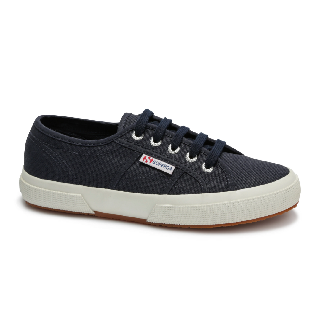 The Superga Cotu Classic Sneaker in navy blue features a durable canvas upper, white rubber sole, brown gum outsole, white eyelets, black laces, and a signature logo tag on the side.