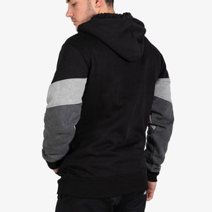 A man is shown from the back wearing the UNIT Graded Fleece Hoodie, which features color-blocked black, gray, and dark gray sleeves and a sherpa-lined hood, against a plain white background.
