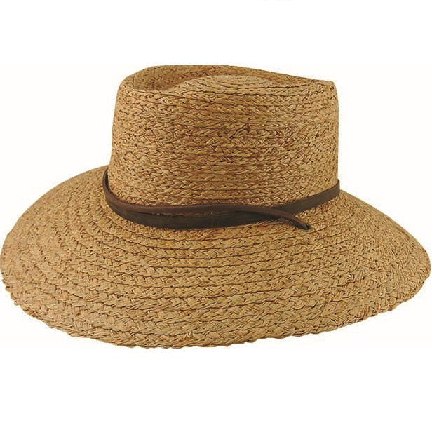 The Avenel Braided Raffia Suede Band Hat features a wide-brimmed design in a natural straw color, crafted from braided raffia, with a slightly dented crown and a brown leather band encircling its base. This stylish hat offers UPF 50+ protection to provide ample shade and is displayed laid flat against a white background.