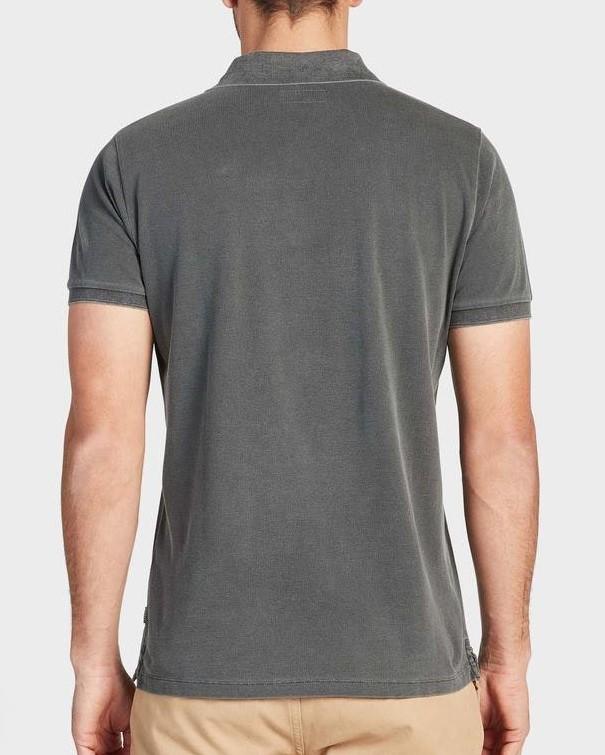 A person is seen from the back wearing a short-sleeved, charcoal gray Academy Brand Academy Polo made of cotton pique and light khaki pants. The comfortable polo stands out against the plain, light-colored background.